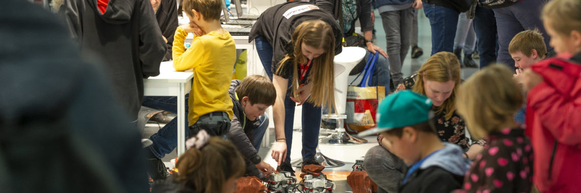 Gewimmel mit Lego Robotern und Menschen an der Messe